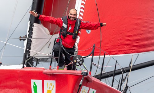 Damien Seguin, les bras levés victorieux à l'avant de son Imoca